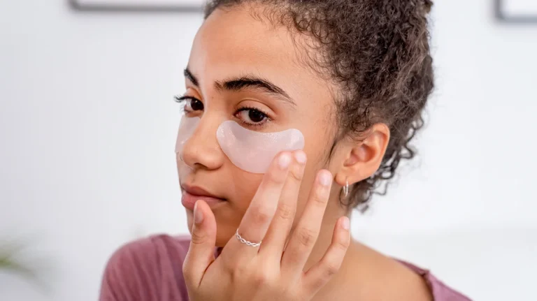 Black teenager applying under eye patches 1296x728 header Seven Eye Beauty Treatments That Will Define 2025