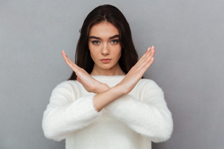 portrait serious young woman showing crossed hands gesture scaled 1 The Art of Saying No: Setting Financial Boundaries with Friends and Family