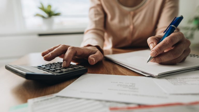 Knowing What Your Real Living Expenses Are 1 woman calculator budget finances SOMN19162 869247602 is 1560x880 Knowing What Your Real Living Expenses Are